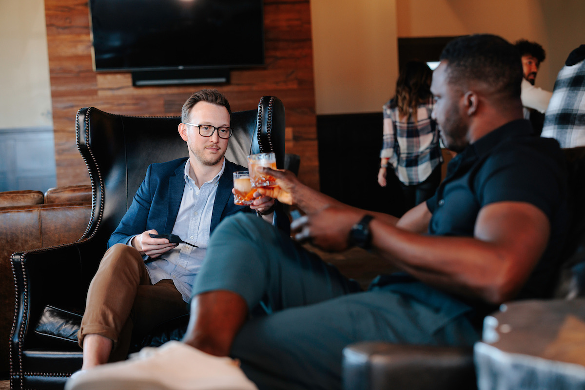 Two members raising glasses in the lounge