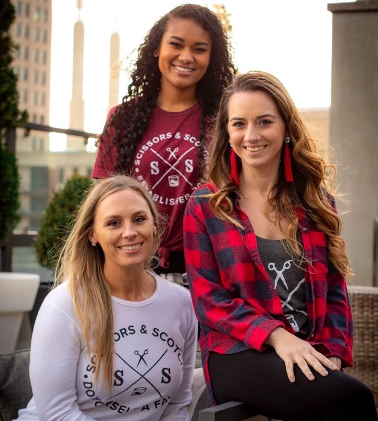 Three Scissors & Scotch team members in branded shirts